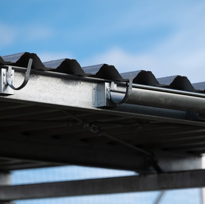 Installation d'une Gouttière Métallique sur Toiture en Tôle Gouttière métallique fixée sur une toiture en tôle ondulée avec des supports de fixation robustes.