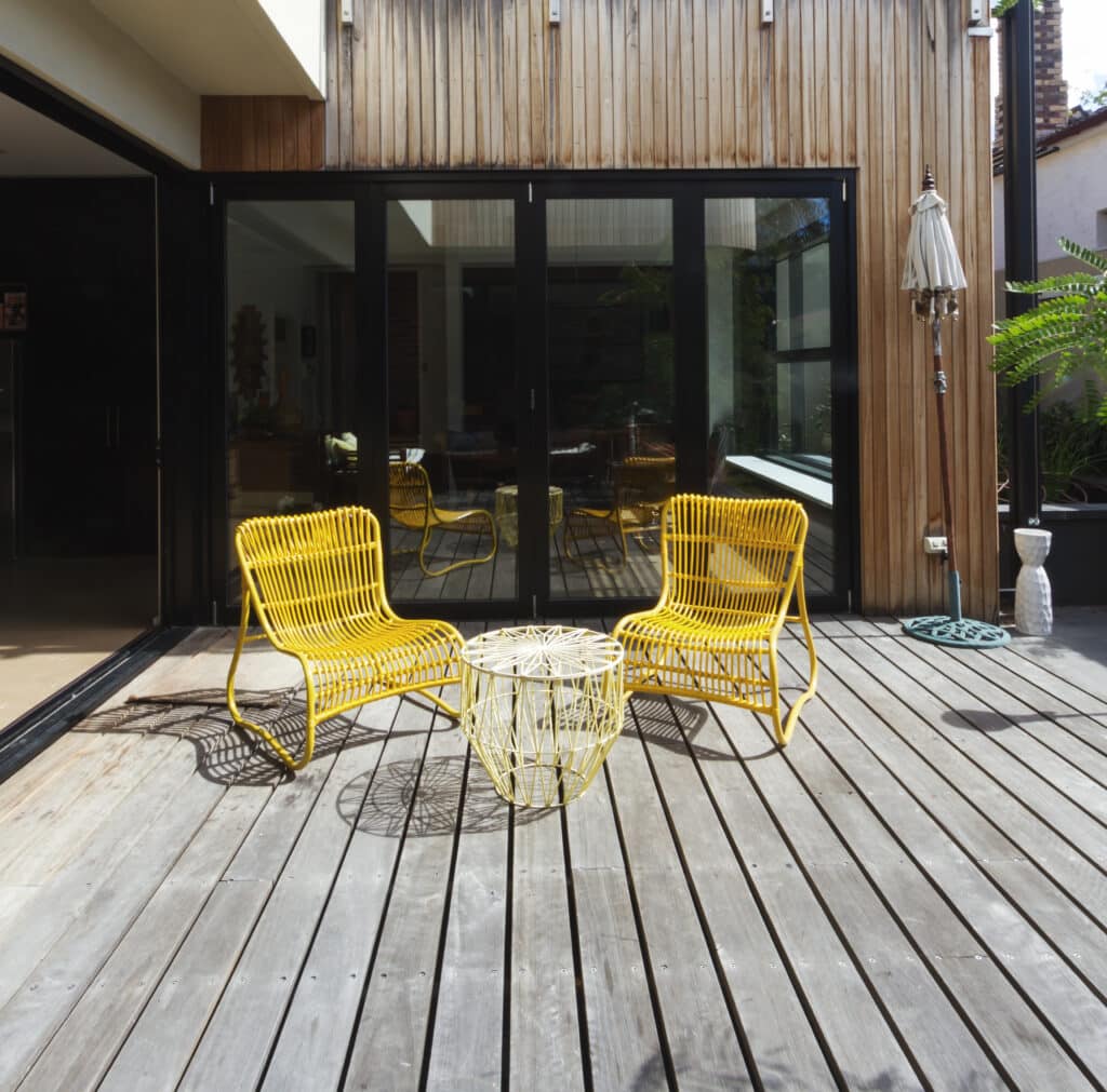 Chaises de Jardin Jaunes sur Terrasse en Bois Design Salon de jardin avec chaises jaunes et table design sur terrasse en bois devant une maison moderne.